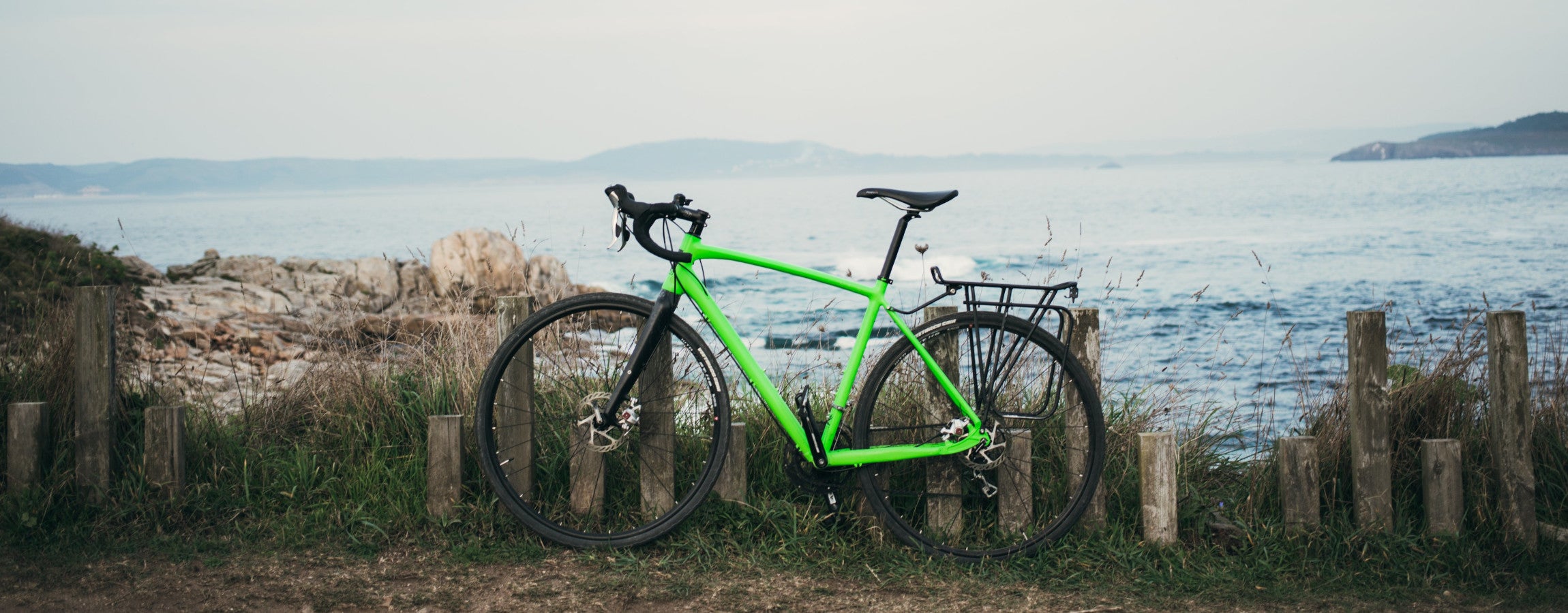 Grünes Fahrrad stehend vor dem Meer